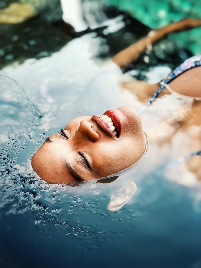 A women relaxing in water after successful plastic surgery recovery